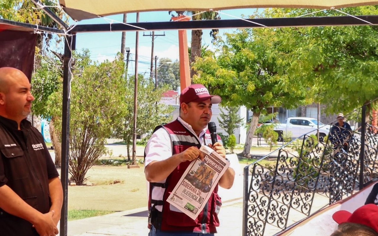 David Mendoza en la Asamblea Informativa de Agua Prieta, con un ejemplar de Regeneración